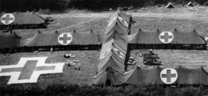vue aérienne d'un hôpital de campagne avec une croix rouge au sol ainsi que plusieurs autres sur les tentes.